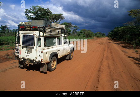 Landrover sur une route en terre africaine rouge, Zambie Banque D'Images