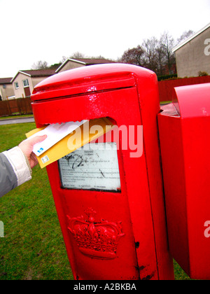 Close up de main de personne de l'affichage des lettres en rouge UK post box Banque D'Images