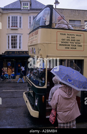 Femme avec parapluie de monter dans un bus touristique dans la région de Broad Street Oxford England UK Banque D'Images