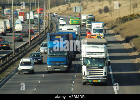 Vue avant camions hgv remorque articulée conduite sur autoroute à trois voies avec épaulement dur à drain français et barrière anti-collision en acier au Royaume-Uni Banque D'Images