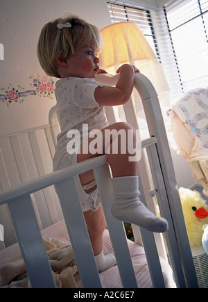 Shot verticale de jeune fille escalade de lit-bébé à l'intérieur piscine MR ©Myrleen Pearson ...Ferguson Cate Banque D'Images