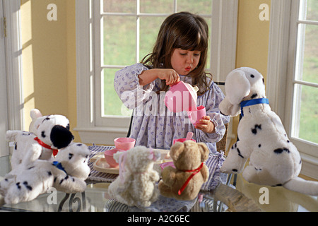 Coup horizontal de jeune fille jouer faire croire tea party avec ses animaux en peluche Banque D'Images