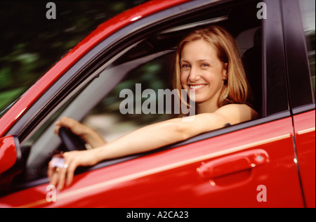 Jeune femme woman looking at viewer comme elle par les lecteurs dans une voiture Banque D'Images