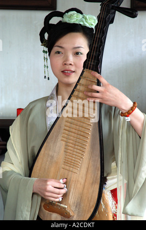 Femme jouant de la musique traditionnelle dans le jardin pour la détente dans Suzhou, Chine Banque D'Images