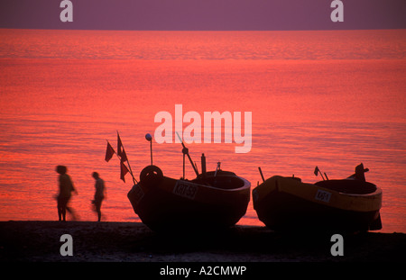 Les bateaux de pêche et les gens au coucher du soleil à la plage de Katy Rybackie près de Gdansk en Pologne Banque D'Images