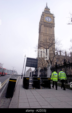 Les obstacles à l'extérieur de l'anneau d'acier chambres du parlement de Westminster big ben avec les fonctionnaires de police patrouiller périmètre Banque D'Images