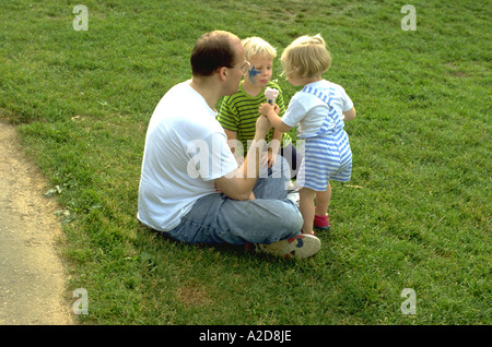 L'âge de 35 ans père cône partage au lac Harriet parc avec son fils et sa fille de 4 et 2. Minneapolis Minnesota USA Banque D'Images