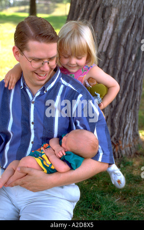 Papa l'âge de 30 ans et sa fille de 3 ans admirant nouveau bébé garçon. Merriam Park St Paul Minnesota USA Banque D'Images