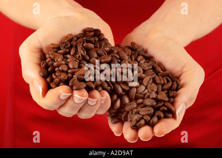 Femme AVEC POIGNÉE DE GRAINS DE CAFÉ Banque D'Images