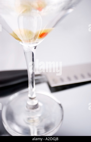 Martini avec olives en verre à côté de fuel sur le comptoir Banque D'Images