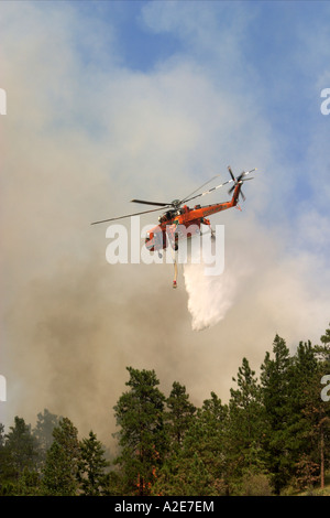 L'eau chute d'hélicoptère Sikorsky sur un feu de forêt avec de la fumée à l'arrière-plan Banque D'Images