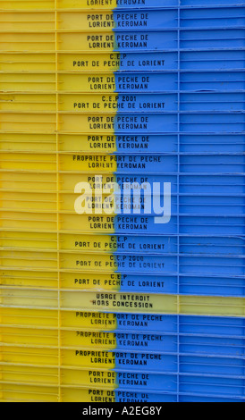 Une pile de plastique jaune et bleu vide les boîtes de poisson sur le quai à Newlyn Banque D'Images