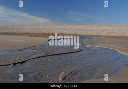 L'eau douce s'écoule à travers la plage de sable à marée basse l'eau s'écoule du Romney Marsh Banque D'Images