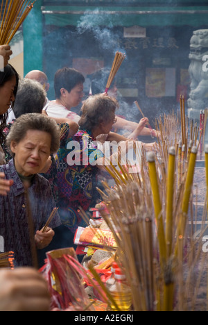 dh Wong Tai Sin Temple WONG TAI SIN HONG KONG Old lady joss bâtons temple encens bâton chinois taoïste scène chine taoïsme foule adorateurs Banque D'Images