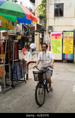 Dh Cheung Chau HONG KONG Old man mountain biking location rues du village cycliste chinois Banque D'Images