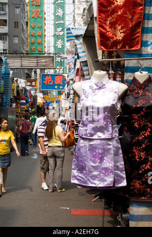 dh Ladies Market MONG KOK HONG KONG couple touristique shopping dans le marché de rue chinois soie short cheongsam robe tung choi vêtements de touristes mongkok Banque D'Images