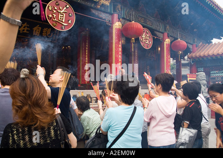 dh Wong Tai Sin Temple WONG TAI SIN HONG KONG adorateurs avec des bâtons de jos bâtiment de temple adoration taoïste gens groupe de taoïsme foules chinoises Banque D'Images