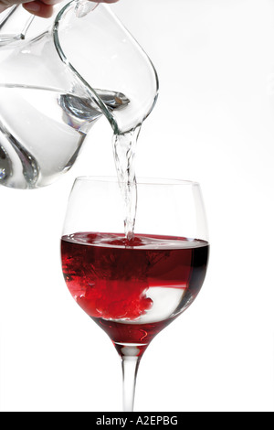 Part verser de l'eau dans un verre de vin, close-up Banque D'Images