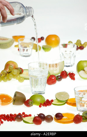 Part verser de l'eau dans le verre, fruits frais Banque D'Images