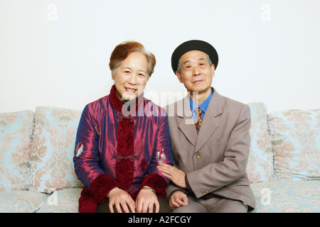 Portrait of a senior man sitting on a couch with a young woman Banque D'Images