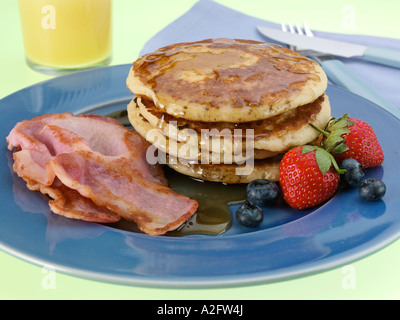 Une pile de Crêpes avec sirop d'érable américain fraises bacon Banque D'Images