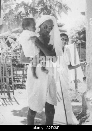 MKG33073 Mahatma Gandhi portant un enfant à l'Ashram Sevagram Wardha Maharashtra Inde dans le dos de sa mère Mai 1940 Banque D'Images