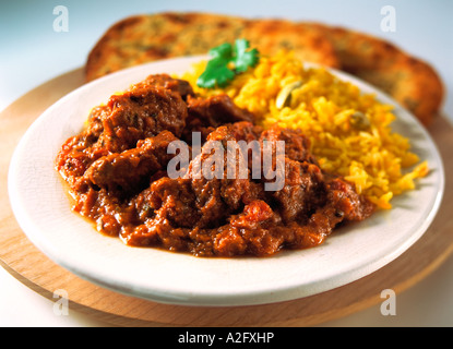 Une assiette d'agneau rogan josh et riz safrané avec du pain naan dans l'arrière-plan Banque D'Images