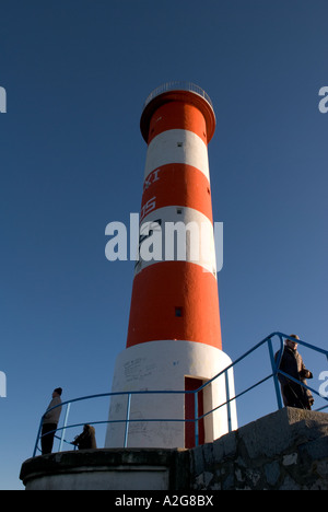 Un angle bas photo de phare rouge et blanc avec des personnes à sa base Banque D'Images