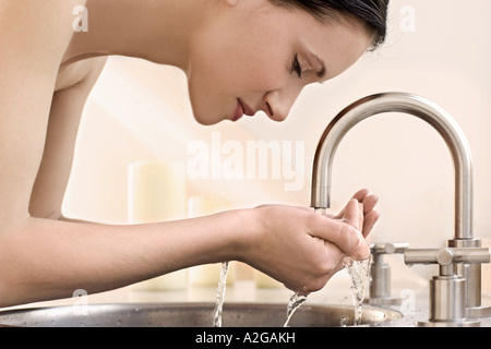 1215529 piscine Télévision Salle de bains jeune femme brunette 2530 Eau du robinet lavabo main mains hygiène laver soins de beauté close up Banque D'Images