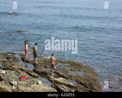 Les jeunes de la pêche les rochers, El Faro, Mijas Costa, Costa del Sol, Espagne, Europe, Banque D'Images