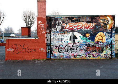 Peinture murale et de l'écriture graffiti peint sur la paroi latérale d'une London School et centre de jeunes. Banque D'Images