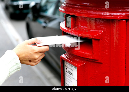 Personne qui représente une lettre dans un bureau de poste rouge Affichage fort sur le côté d'une rue Banque D'Images