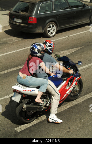 Vue aérienne regardant vers le bas du dessus couple moto portant des casques de sécurité scène de rue trafic Palma Mallorca Majorque Îles Baléares Espagne Banque D'Images