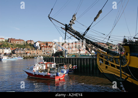 Bateaux de pêche dans le port de Whitby et de proue de navire à voile réplique Grand Turk, North Yorkshire, Angleterre Banque D'Images