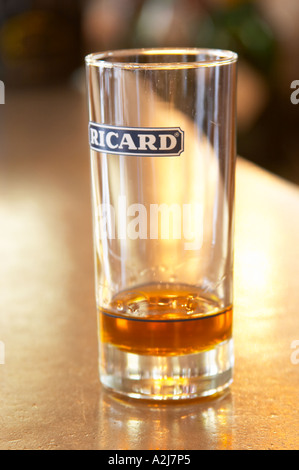 Un verre de pastis 45 Ricard sur un bar zinc dans un café à Paris. Partie d'une série de photos montrant que lorsque vous ajoutez de la glace et l'eau la boisson devient trouble voie lactée Le pastis est un esprit des boissons à saveur de l'alcool avec des herbes telles que l'anis étoilé (badiane, anis étoilé etoile) et d'autres épices. Il est parfois appelé pastis absinthe ou absinthe. Il est servi dans un grand verre avec de la glace et de vous verser de l'eau sur elle. Il est nuageux voie lactée quand l'eau est ajoutée. C'est une boisson apéritif en Provence Sud de la France. Banque D'Images