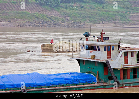 Chine Yangtze River remorqueur chinois traverse la rivière Yangtze, passé des rochers avec un panneau d'avertissement Banque D'Images