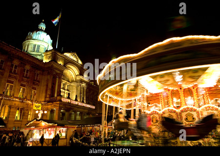 Un carrousel traditionnel partie de l'assemblée annuelle du marché de Noël de Francfort qui s'est tenue à Birmingham avec le Conseil maison dans l'arrière-plan Banque D'Images