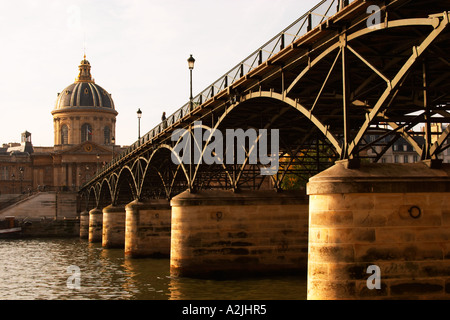 Le Pont des Arts à Paris (France) sur la Seine conduisant à l'Académie française (Institut de France) avec un homme debout sur le pont de fumer. Paris France Europe Banque D'Images