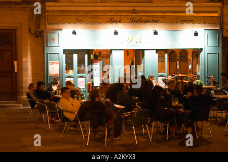 Les jeunes gens assis sur la terrasse à l'extérieur sur la place Pie XII Pie douze carrés, la nuit. Avignon, Vaucluse, Provence, Alpes Cote d Azur, France, Europe Banque D'Images