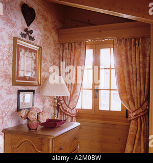 Dans la fenêtre avec les rideaux et le papier peint dans un chalet traditionnel en Suisse Banque D'Images