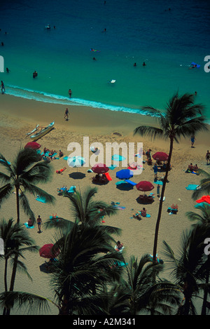 Vue aérienne de palmiers de parasols et de vacanciers sur une plage tropicale Banque D'Images