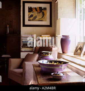 Fauteuil violet par coffre en bois avec la cuvette dans la salle de séjour du moulin restauré Banque D'Images