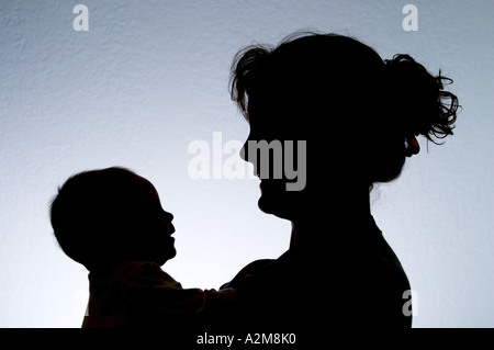 Silhouette of mother holding baby daughter Banque D'Images