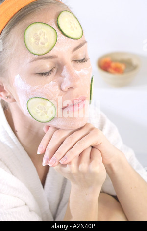 Close-up of young woman with facial mask et tranches de concombre sur le visage Banque D'Images