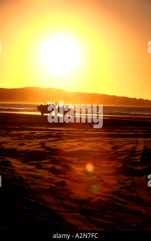 Quatre roues motrices véhicule utilitaire tractant une remorque bateau au coucher du soleil sur la plage de Fraser Island Queensland Australie Banque D'Images