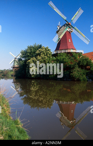 Reflet de ses moulins à vent traditionnels dans la région de canal, Greetsiel, Frise orientale, Basse-Saxe, Allemagne Banque D'Images