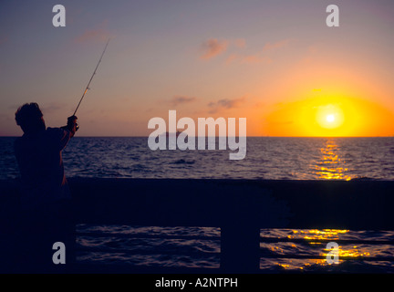 Un pêcheur jette son trajet vers le coucher de soleil à Key West en Floride Banque D'Images