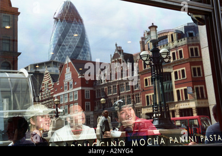 Royaume-uni, Angleterre, Londres. Les touristes à l'intérieur de cafe admirer les toits de la ville telle que reflétée dans la fenêtre Banque D'Images