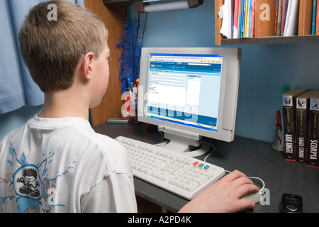 Blanc de 12 ans British school boy MSN emailing sur ordinateur à la maison Banque D'Images