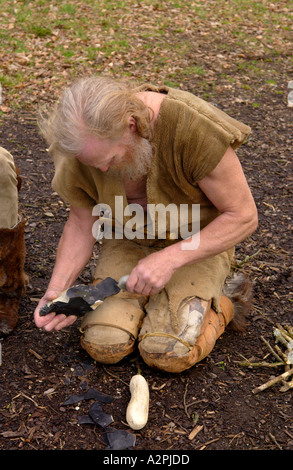 L'homme préhistorique Stoneage professionnel reenactors knapping flint au Musée de la vie galloise Cardiff St Fagans Wales UK Banque D'Images